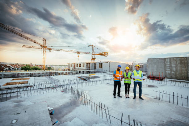 gettyimages-1345384816-612x612 Employees working on construction site, wearing protective equipment and discussing next construction phase