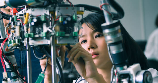 gettyimages-2077222742-612x612 Two students collaborate intently in a high-tech robotics lab, exemplifying teamwork in scientific innovation and education.