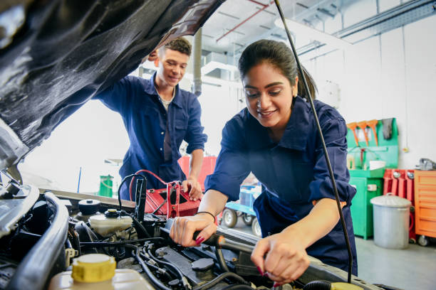 gettyimages-914314364-612x612 Two car mechanic students working in garage at FE college, young woman learning mechanical skills